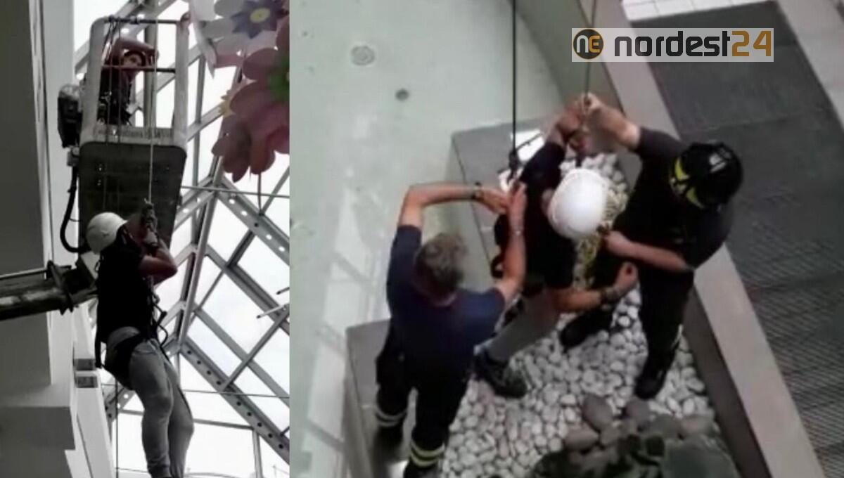 Operaio bloccato nella notte sulla cesta di una piattaforma aerea al centro commerciale - 