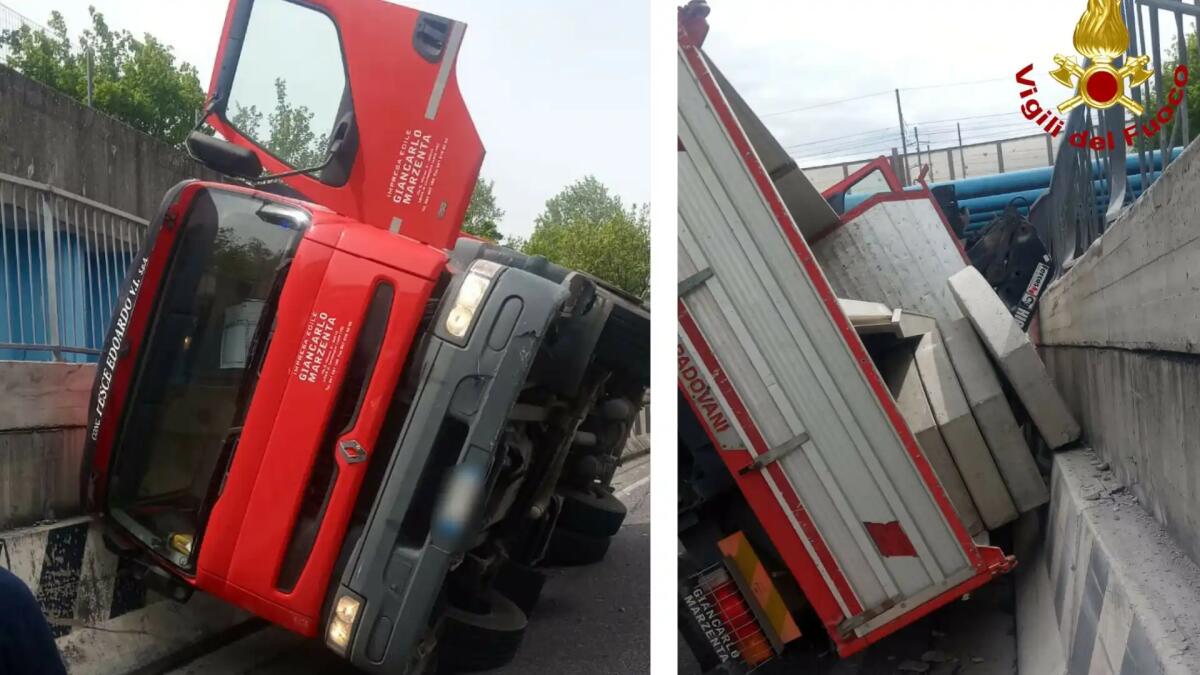 Camion carico di contrappesi di cemento si rovescia lungo la strada - 