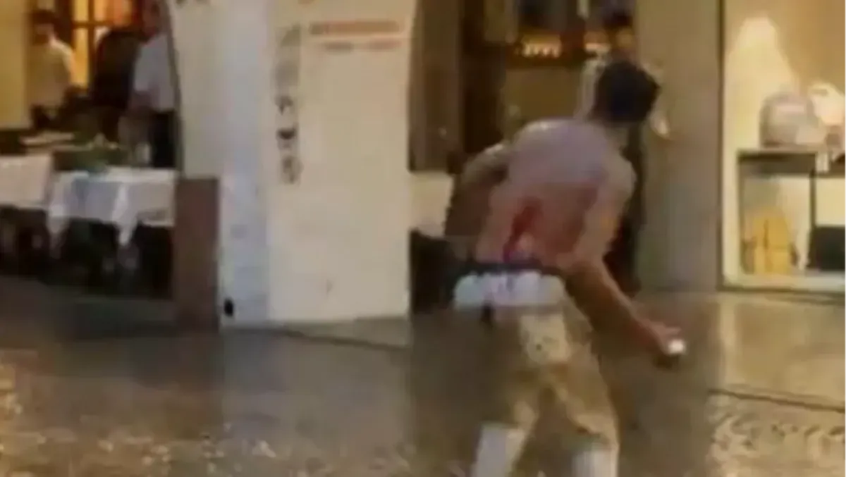 Choc in pieno centro città: uomo insanguinato corre a torso nudo sotto la pioggia e semina il panico - Le immagini diffuse sui social
