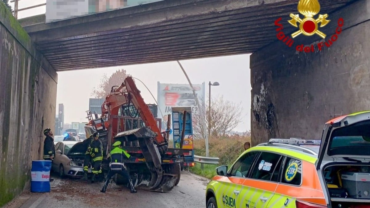 Escavatore cade da un camion e piomba su un'auto: veicolo schiacciato, conducente miracolata - 