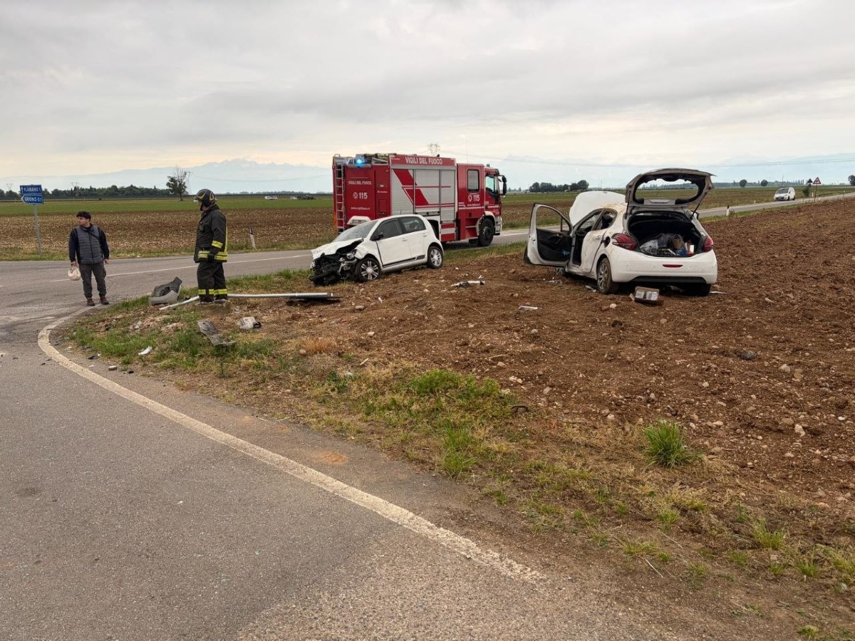 DUE AUTO IN UN CAMPO, FRONTALE, PERSONE ALL'INTERNO CON AUTO RIBALTATA