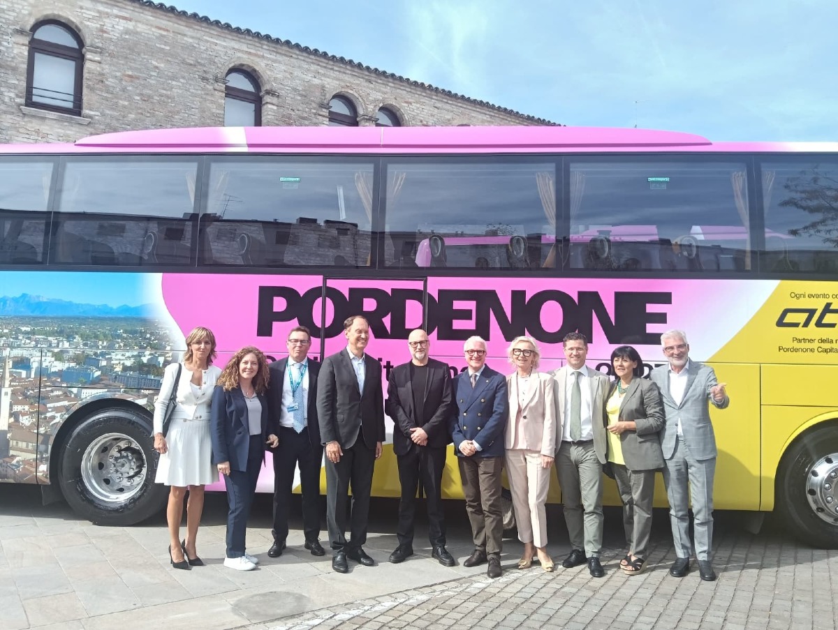 Due bus ATAP con il marchio Pordenone 2027 sulle strade di Italia ed Europa